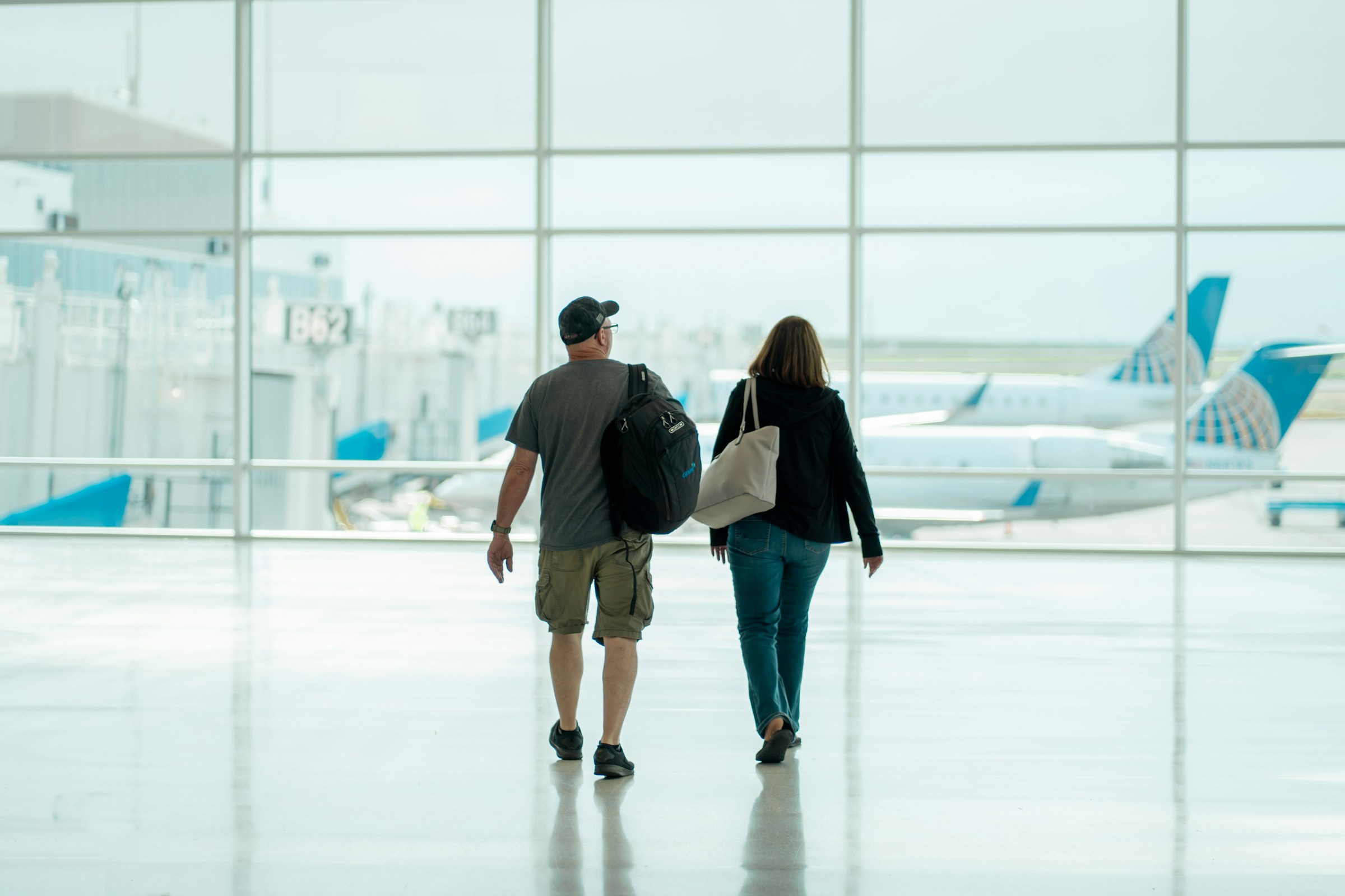 Two travelers walking together through an airport terminal